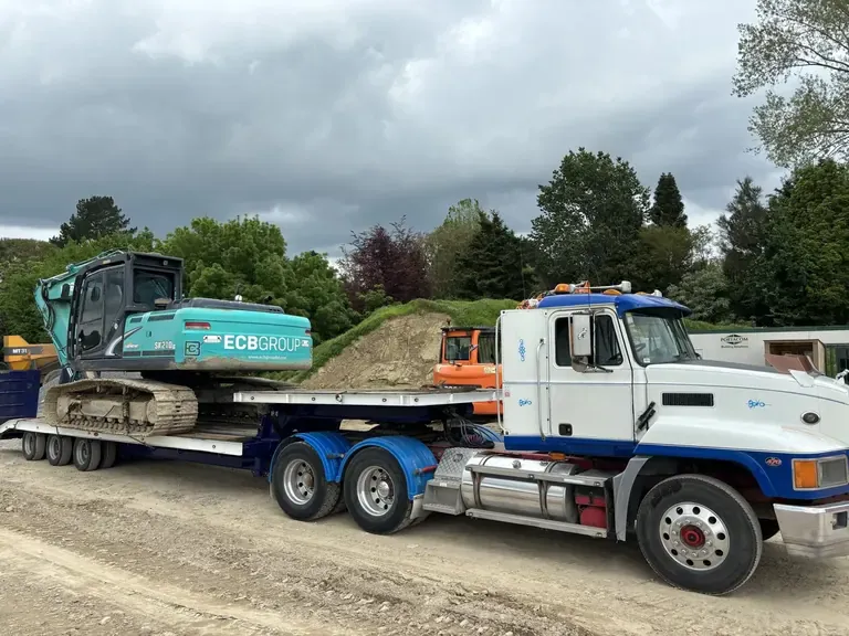 Tracked excavator loaded on a heavy transporter trailer